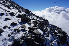 Ślady na świeżym śniegu wśród czarnych bazaltowych skał wyznaczają drogę mojej samotnej wspinaczki na szczyt nieczynnego wulkanu